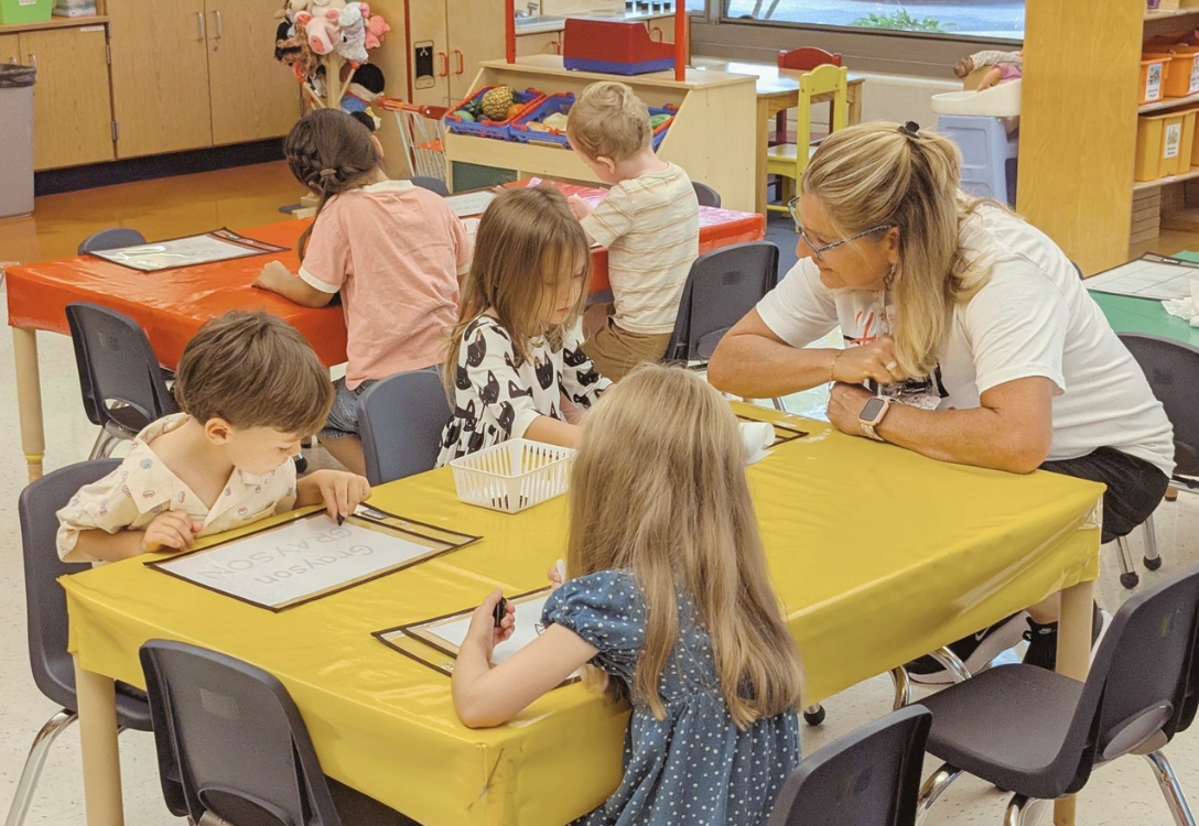 Parapro helping students in EC classroom